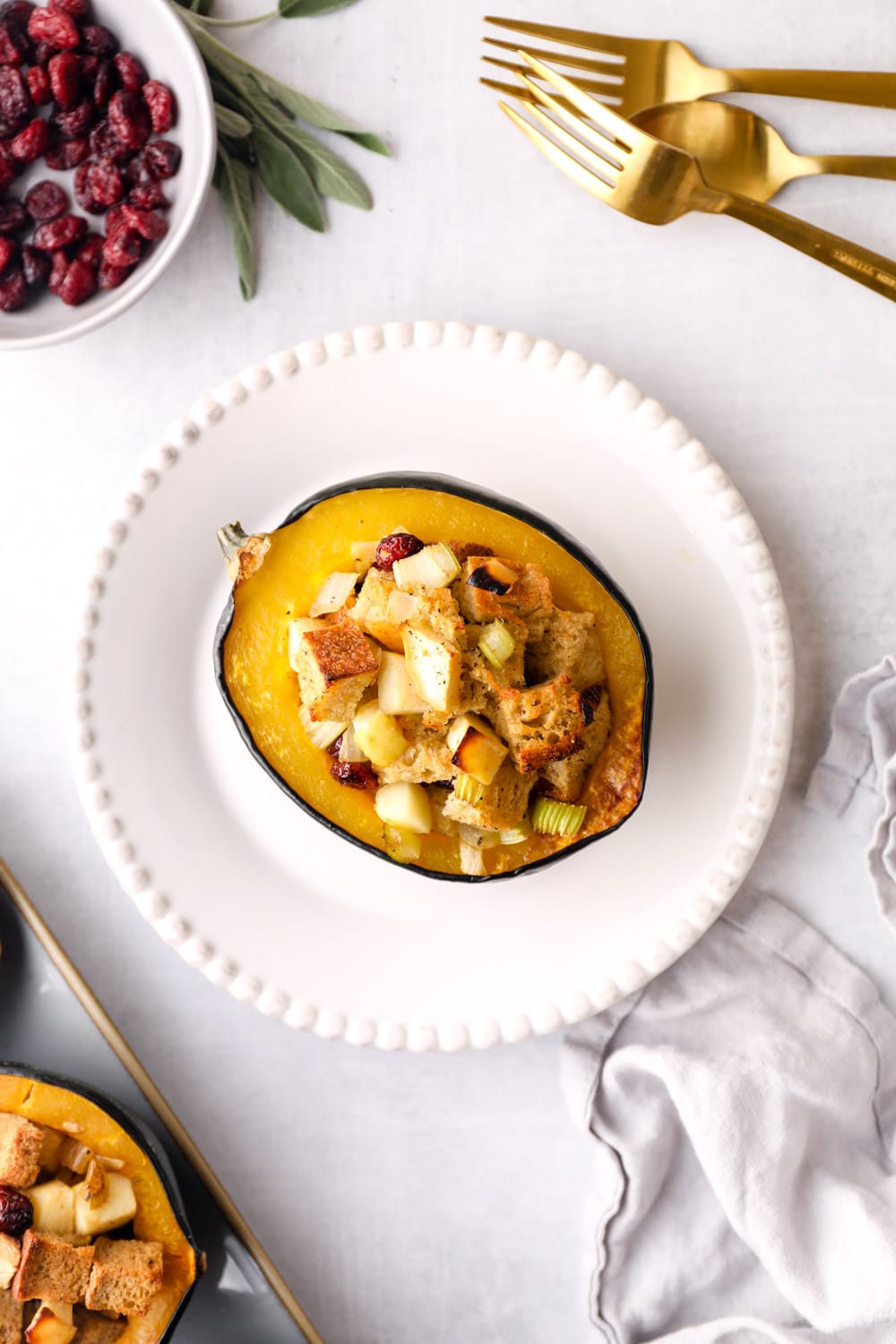 Stuffed Acorn Squash on a single serving white plate with silverware.