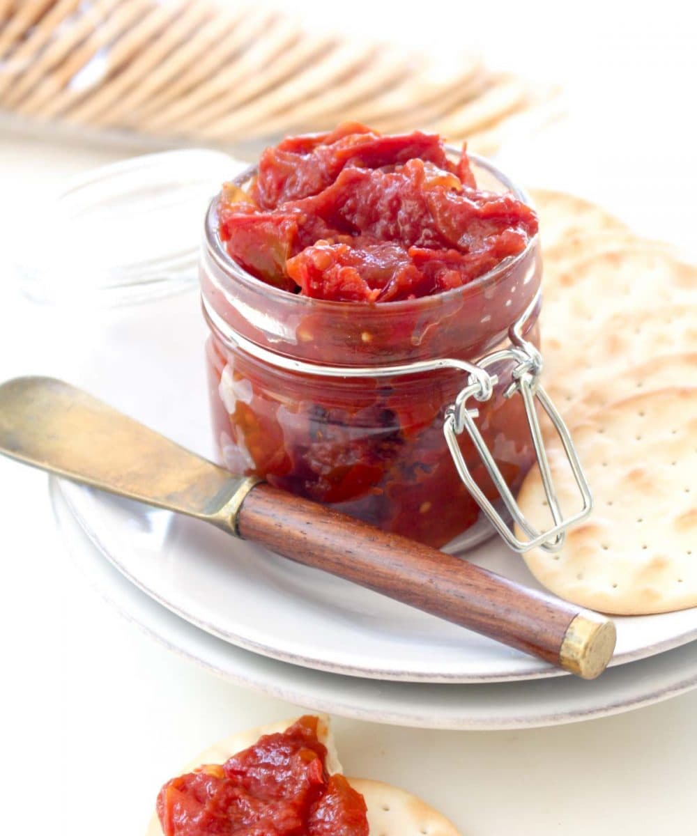 A one pot and one step recipe for homemade tomato jam! The perfect way to use up end of summer tomatoes. This spread is great on sandwiches, crackers, and the perfect addition to your cheese plate.