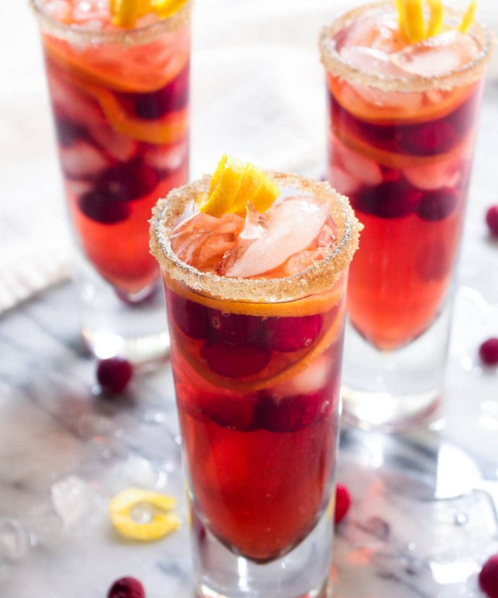 This Kombucha Sangria recipe is a non-alcoholic party drink. Effervescent kombucha gives it a sophisticated feel and cranberries and orange slices infuse this healthy drink with holiday flavor. | CatchingSeeds.com