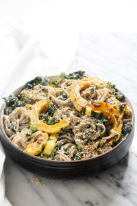 This healthy 9 ingredient Soba Noodle Salad recipe is coated in a creamy and nutty tahini dressing and studded with caramelized winter squash and fresh kale. This gluten-free and vegan meal is equally perfect for lunch or dinner. | CatchingSeeds.com