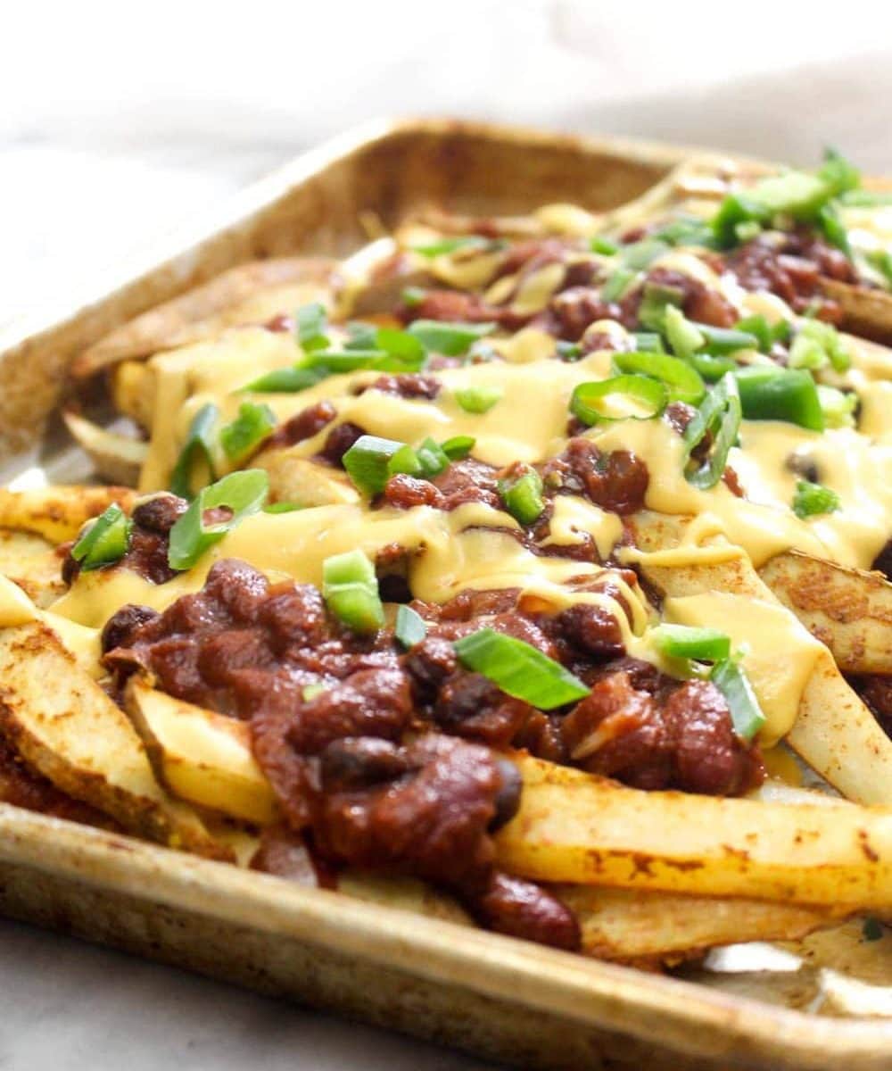 These Vegan Chili Cheese Fries are layers and layers of flavor. They are the perfect recipe for a game-day party, and healthy enough to eat as a weeknight dinner! | CatchingSeeds.com