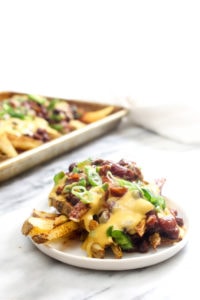 These Vegan Chili Cheese Fries are layers and layers of flavor. They are the perfect recipe for a game-day party, and healthy enough to eat as a weeknight dinner! | CatchingSeeds.com