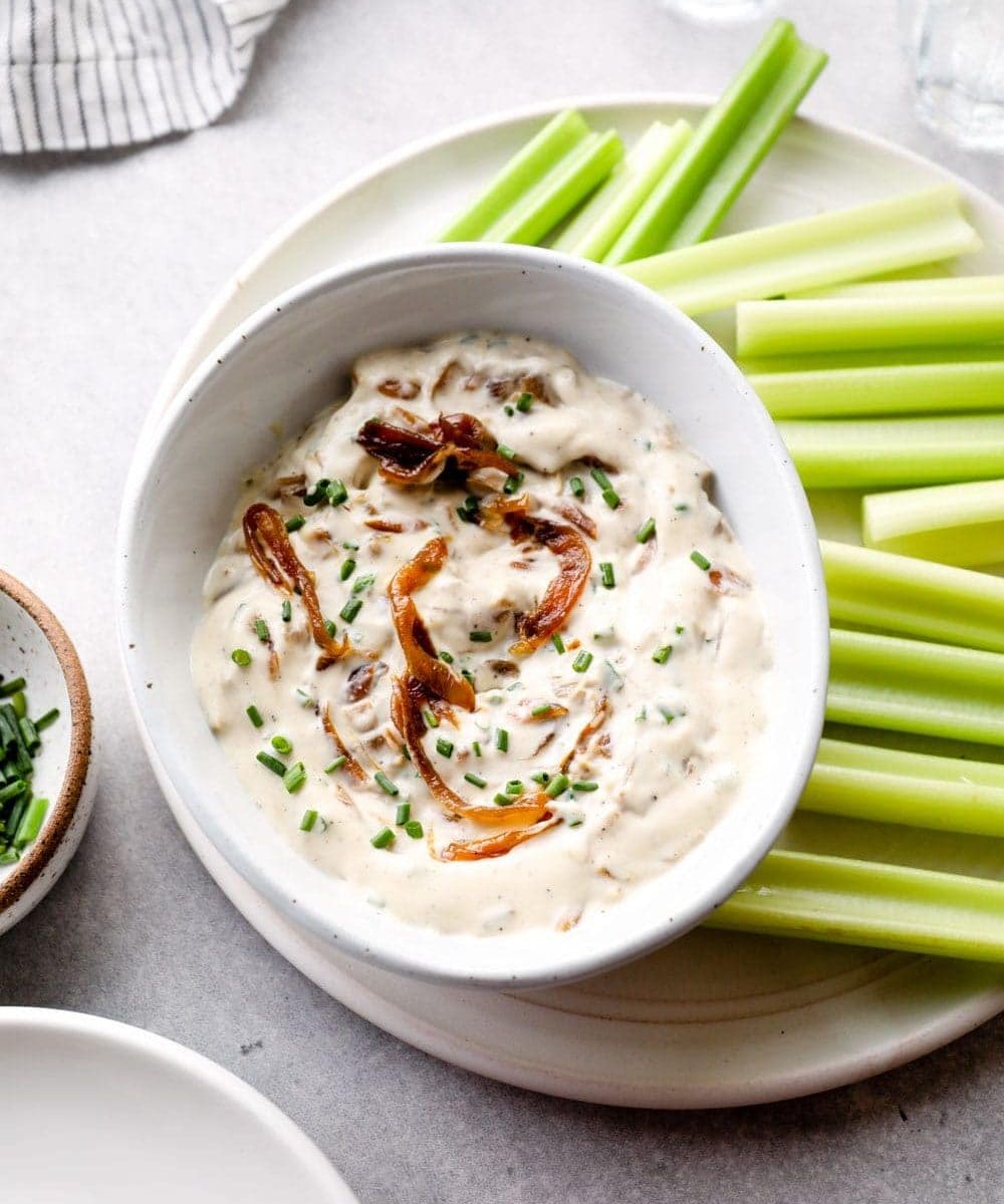 Vegan French Onion Dip on a platter with veggies.