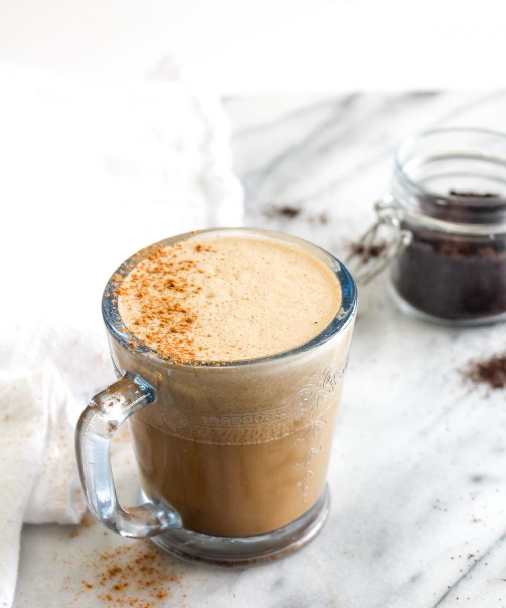 Three quarters view of vegan oil free bulletproof coffee with foam and cinnamon.