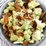 This Healthy Vegan Broccoli Salad is an easy recipe that is BIG on flavor. Broccoli is coated in a sweet and creamy dressing and jazzed up with smokey coconut bacon, toasty seeds, and sweet raisins. | CatchingSeeds.com