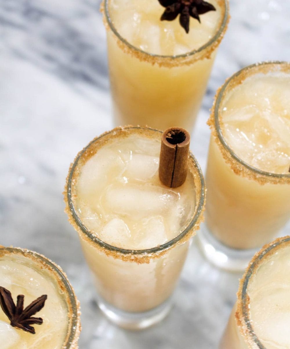 This Spiked Caramel Apple Cider Cocktail tastes like a caramel apple on a stick, but with a splash of rum for good measure! A homemade no-cook caramel sauce, made of dates, coconut milk, and spices, adds a real kick of Fall flavor! | CatchingSeeds.com