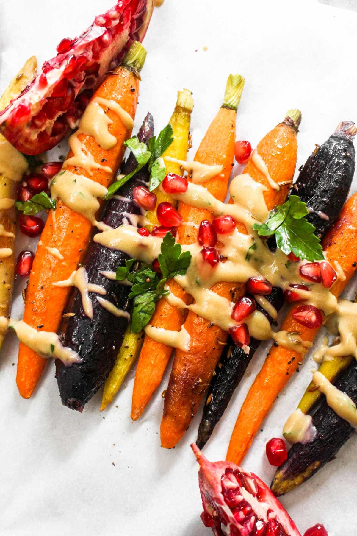 This 7 ingredient Whole Roasted Carrots with Maple Tahini recipe is easy to make but boasts BIG flavors. This light side dish is paleo and vegan! | CatchingSeeds.com