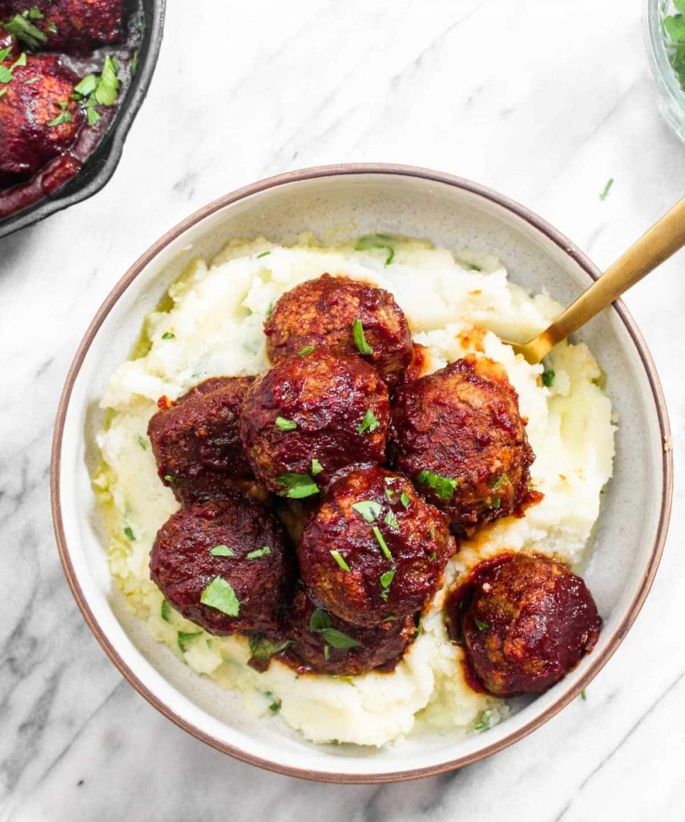 Veggie Meatballs with Cranberry Barbecue Sauce are a proper plant-based Thanksgiving entree recipe. This healthy gluten-free dish is bursting with savory-sweet flavor thanks to a simple homemade BBQ sauce.