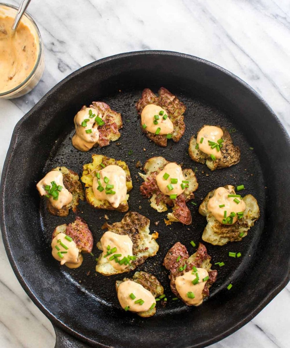 Smashed Potatoes with Chipotle Aioli are an easy 4 ingredient side recipe. Smashing the potatoes before roasting means more of those perfect crispy edges. This side is perfect for dinner or Thanksgiving! Grain-free and vegan, this is a Holiday crowd pleaser that everyone can enjoy! | CatchingSeeds.com