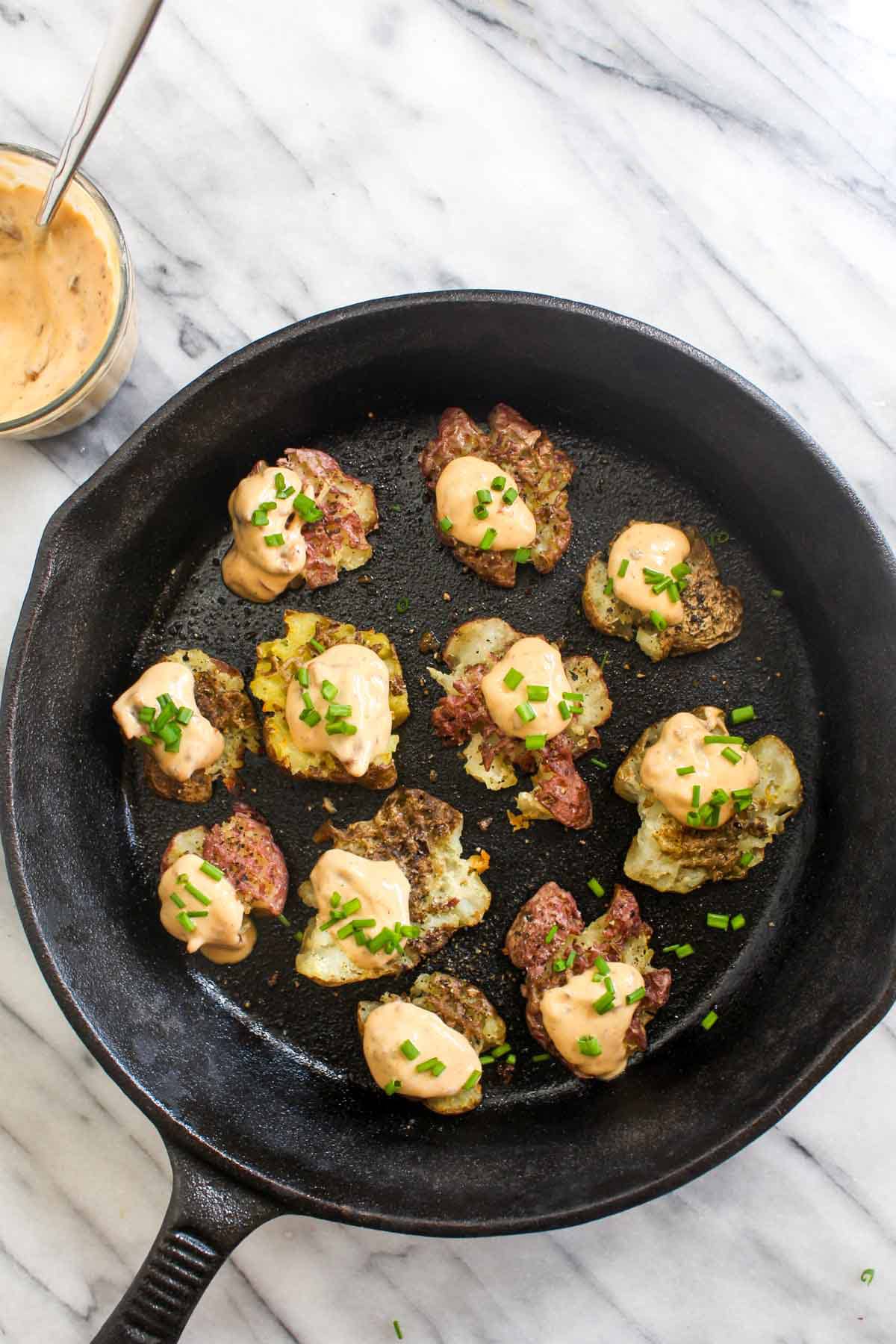 Smashed Potatoes with Chipotle Aioli are an easy 4 ingredient side recipe. Smashing the potatoes before roasting means more of those perfect crispy edges. This side is perfect for dinner or Thanksgiving! Grain-free and vegan, this is a Holiday crowd pleaser that everyone can enjoy! | CatchingSeeds.com