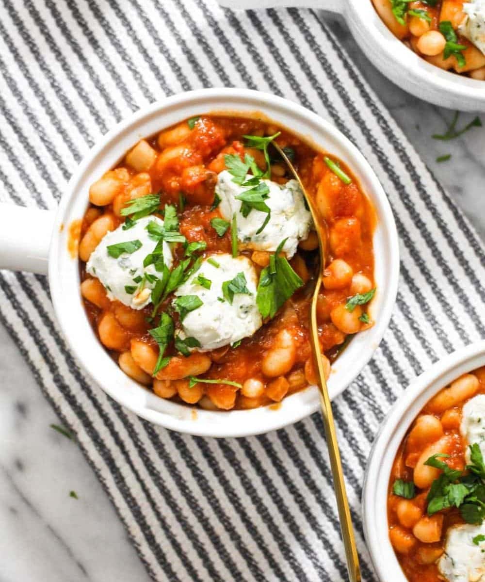 Tomato Cannellini Cassoulet with a homemade tomato sauce is bursting with comforting flavors! The DIY sauce is balanced by using canned beans to make this 8 ingredient side recipe both easy and delicious. The dollops of dairy-free cheese on top add even more rich creamy flavor. | CatchingSeeds.com