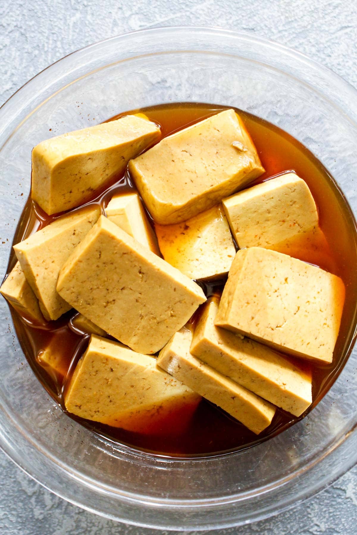 Four ingredient Maple Sriracha Baked Tofu is full of sweet, sticky, and spicy flavor. Marinading the tofu and basting it with a concentrated glaze while it bakes ensures this recipe is loaded with flavor! Vegan, gluten free, grain free, soy free and healthy! | CatchingSeeds.com