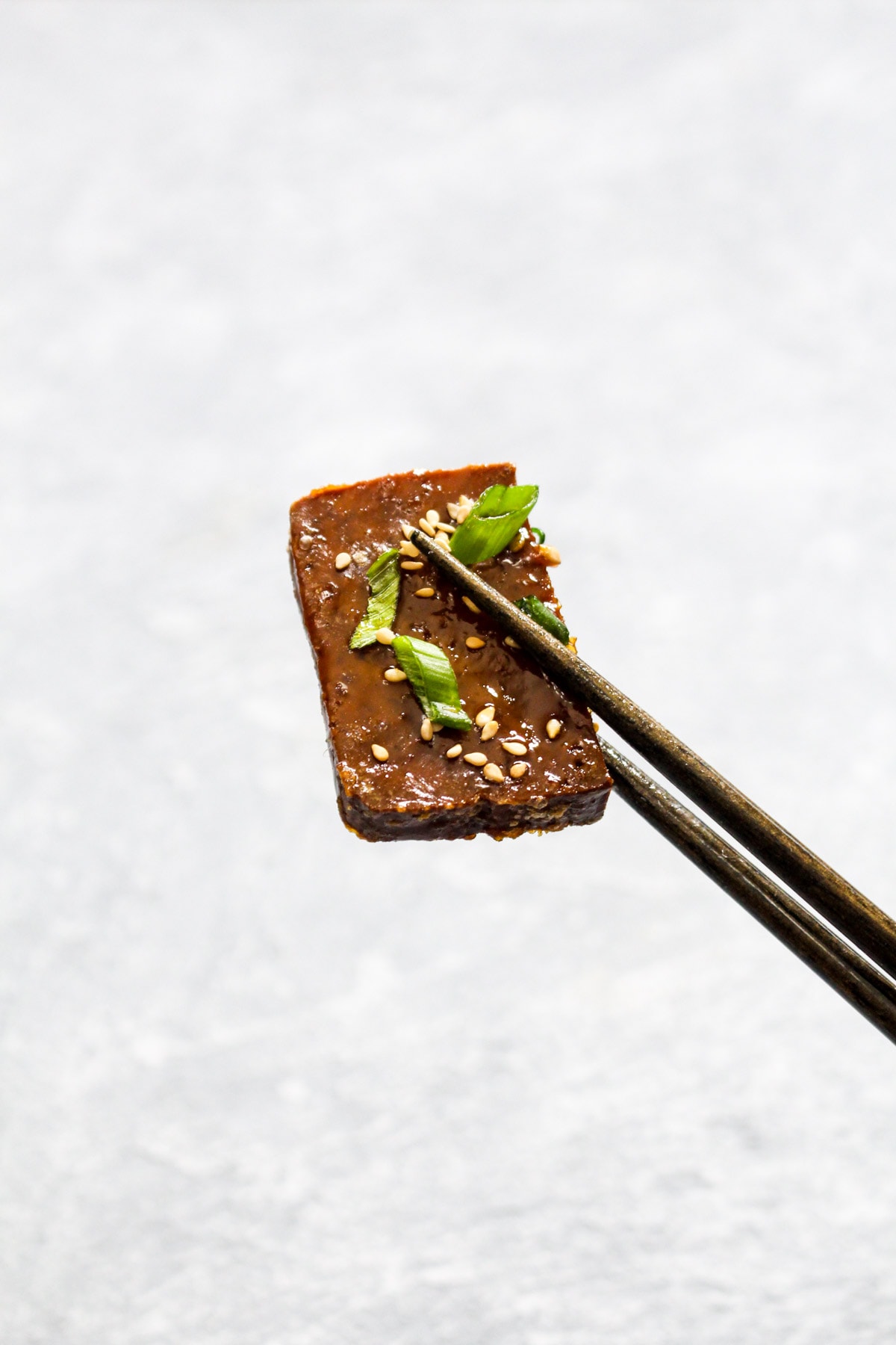 Four ingredient Maple Sriracha Baked Tofu is full of sweet, sticky, and spicy flavor. Marinading the tofu and basting it with a concentrated glaze while it bakes ensures this recipe is loaded with flavor! Vegan, gluten free, grain free, soy free and healthy! | CatchingSeeds.com