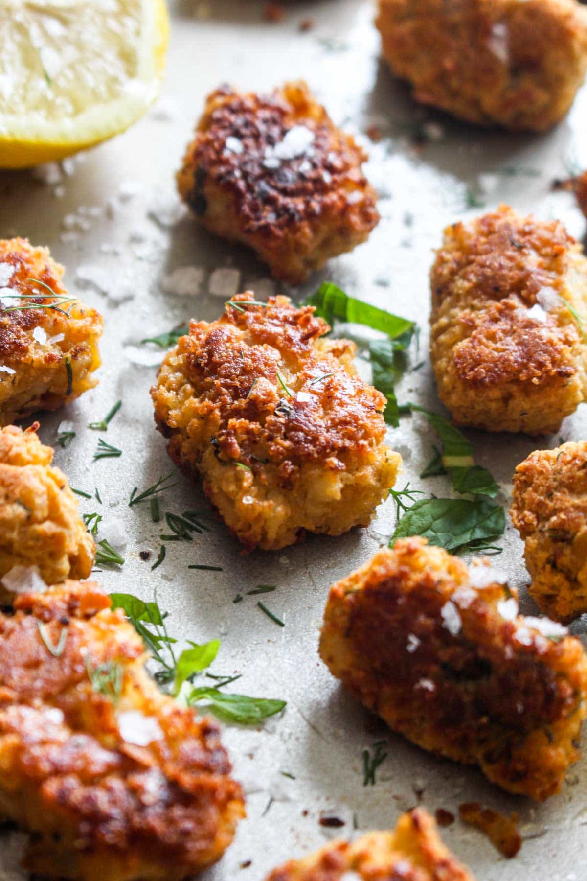 Mediterranean Chickpea Cauliflower Tots are a fun and healthy spin on traditional tots! This side dish gets golden brown and crispy on the outside and is melt in your mouth on the inside. Plus, this recipe sneaks in some extra veggies, is gluten free, and vegan! | CatchingSeeds.com