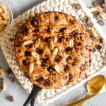 This Protein Packed Chunky Monkey Cookie Skillet recipe is full of peanut butter, banana, and chocolate flavor! This gluten free and dairy-free dessert is baked until the edges are golden and the center is like warm cookie dough. | CatchingSeeds.com