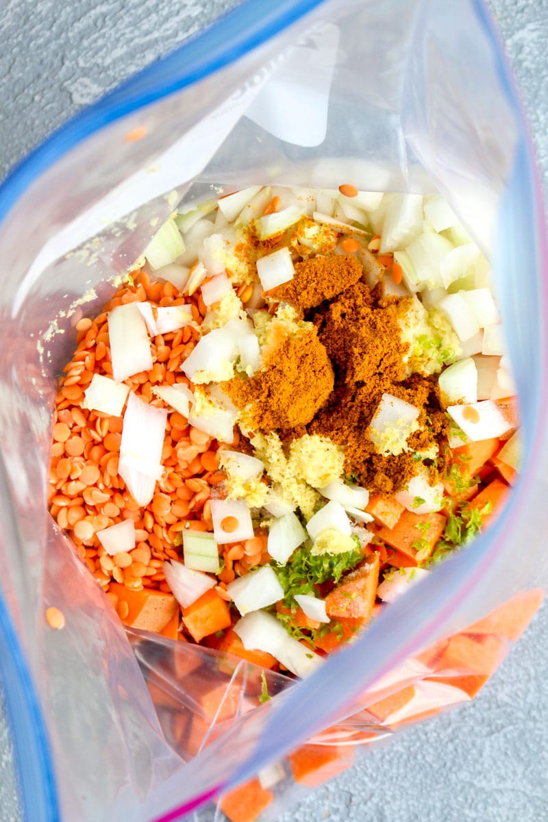 A freezer bag filled with the ingredient to make red lentil sweet potato dahl.