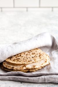 A stack of grain free paleo tortillas wrapped in a towel.