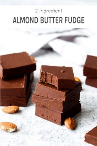 A stack of pieces of chocolate almond butter fudge with a bite out of the top piece.