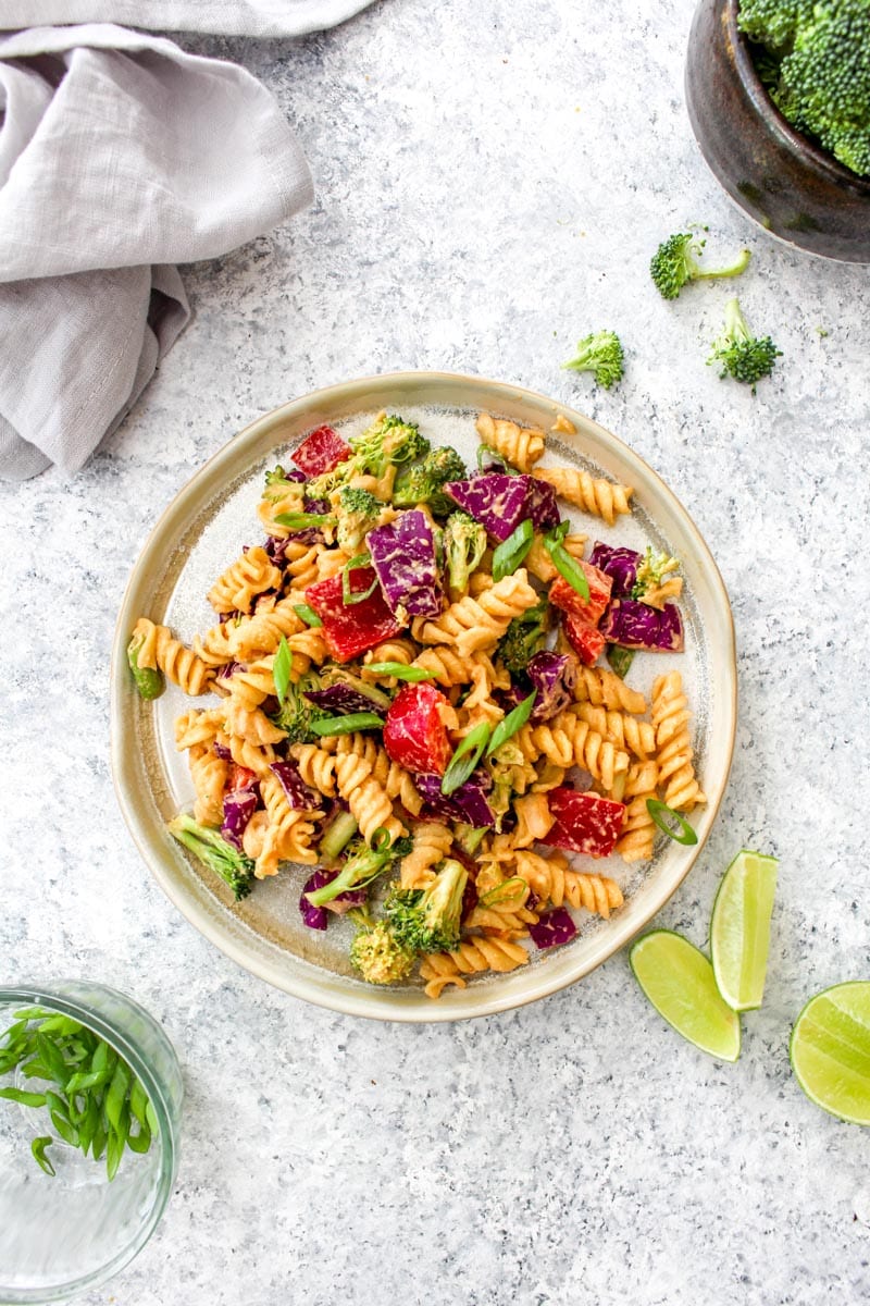 A plate with chipotle pasta salad and lime.
