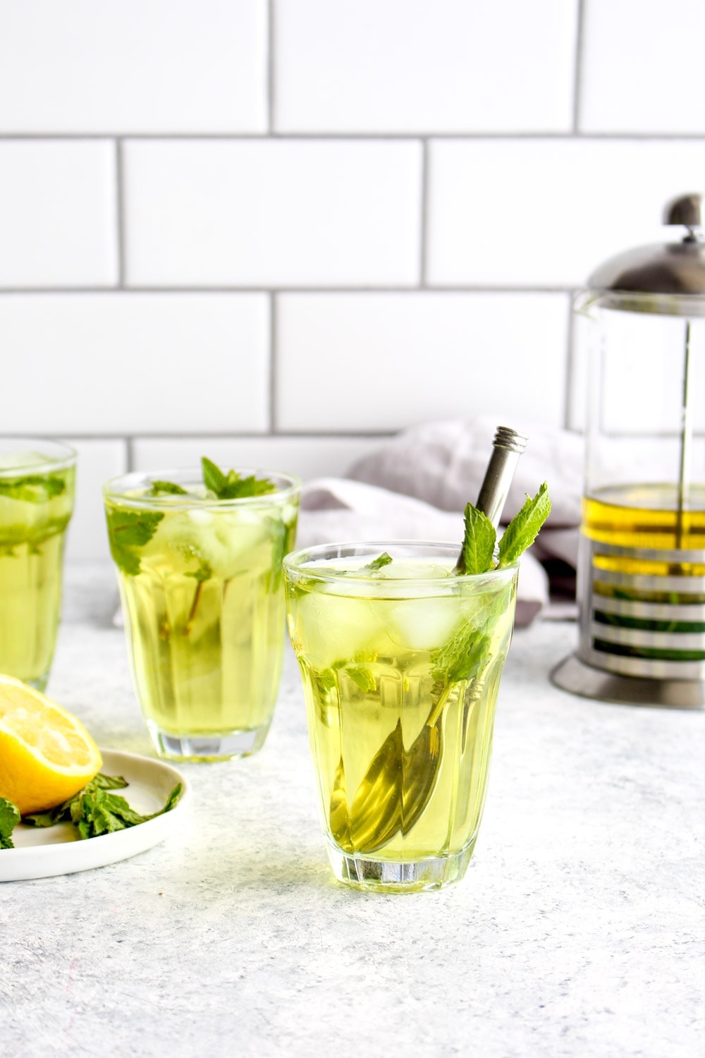 Three glasses of fresh mint iced tea with mint leaves.