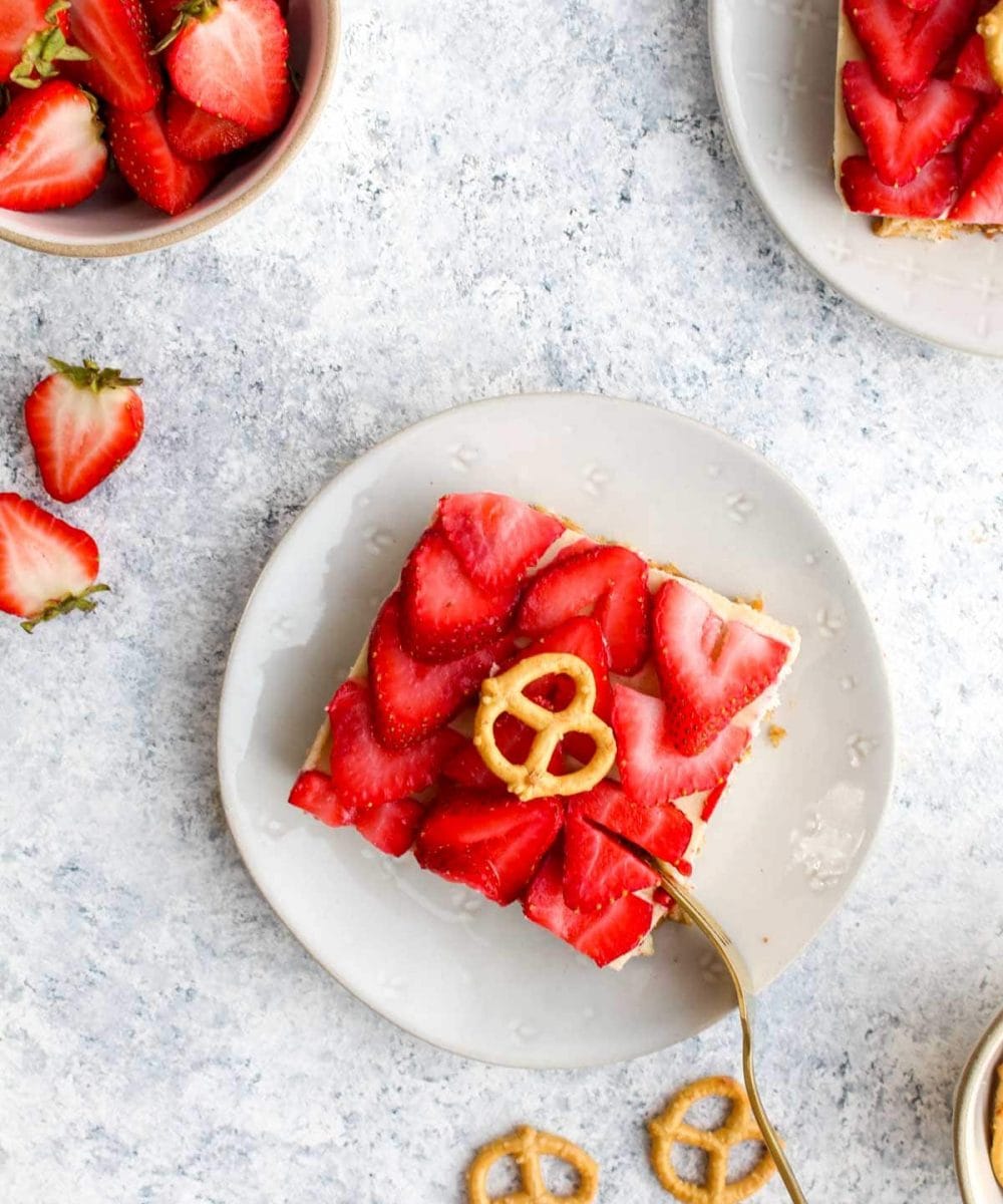 A slice of healthy pretzel salad on a white plate with a gold fork.
