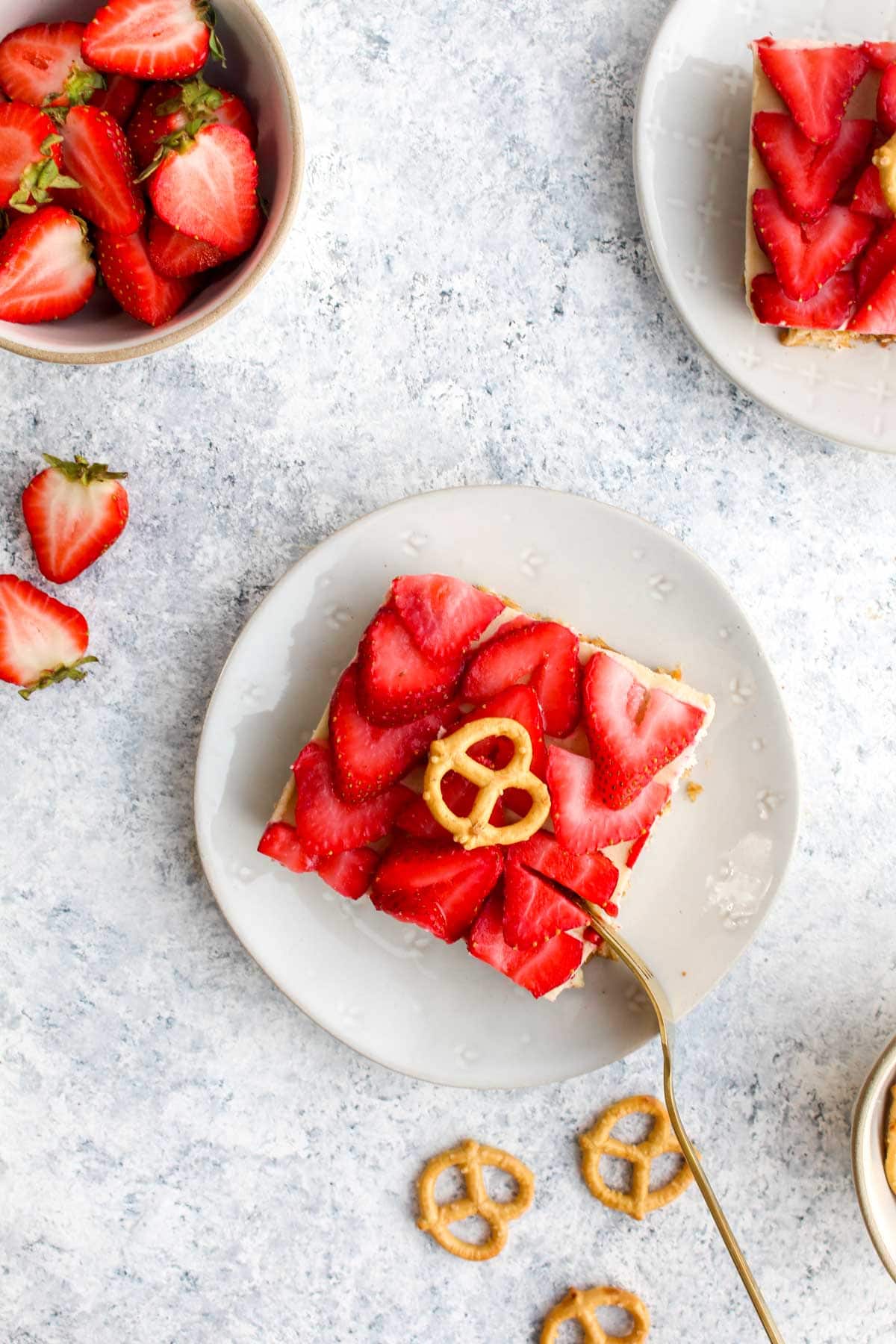 A slice of healthy pretzel salad on a white plate with a gold fork.