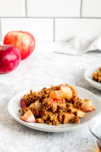 Brunch Apple Crisp on a white plate with apples.