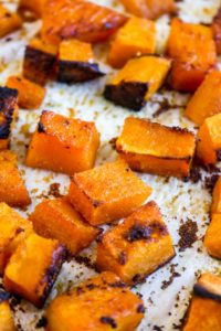Cubed and roasted butternut squash on a sheet tray.