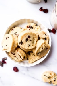 A white plate with shortbread cookies with cranberries and chocolate chips.