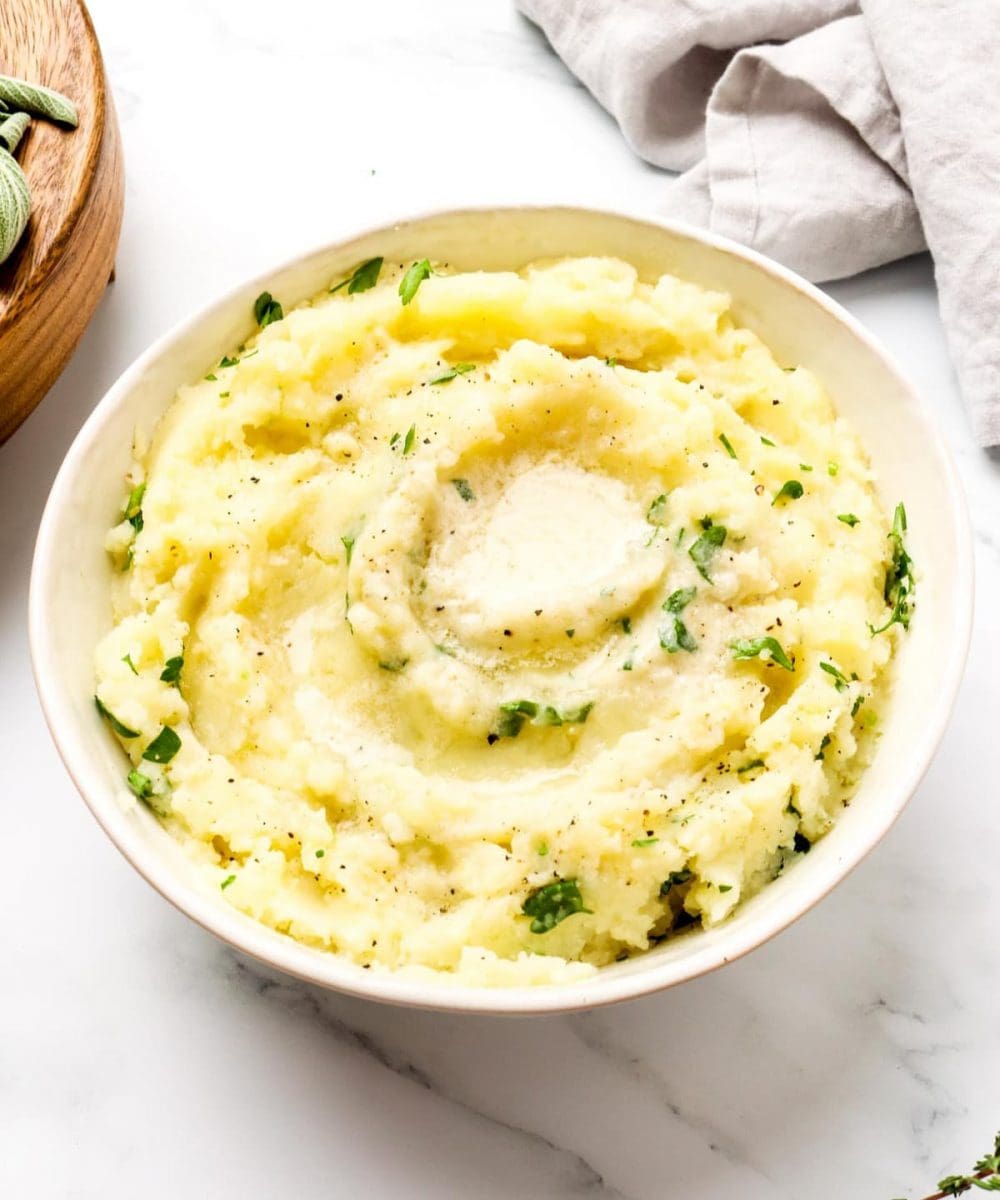 A bowl of dairy free instant pot mashed potatoes with herbs.