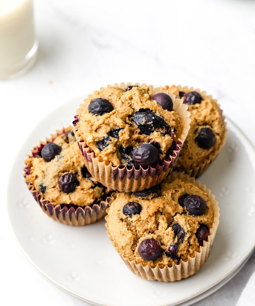 Gluten Free Blueberry Muffins stacked on a serving plate.