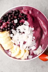 A berry smoothie bowl with banana and coconnut.