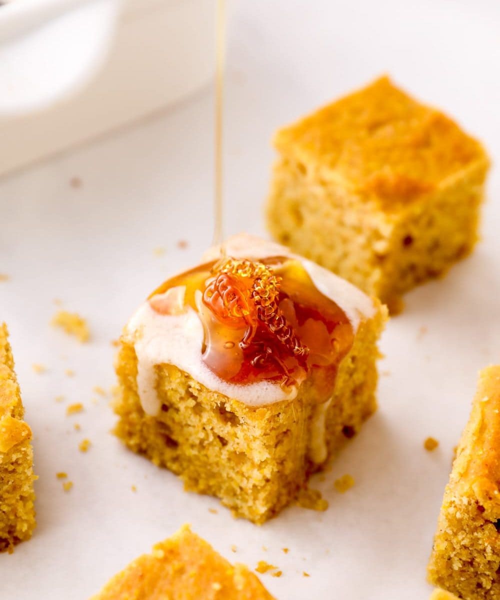 Gluten Free Cornbread with butter and honey being drizzled on top.