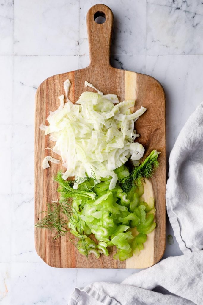 Shaved fennel and celery on a cutting board.