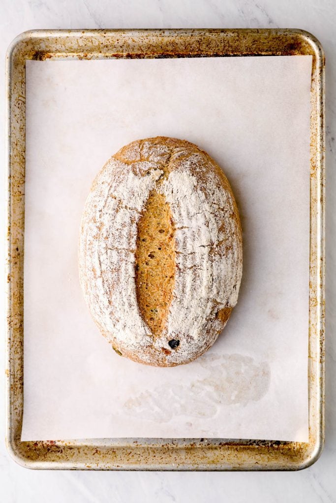The baked loaf on a parchment lined sheet pan.