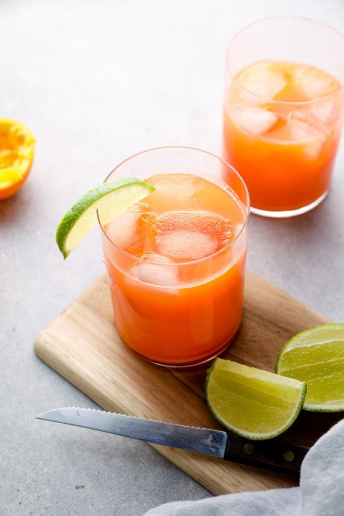 Carrot orange juice in a glass with lime.