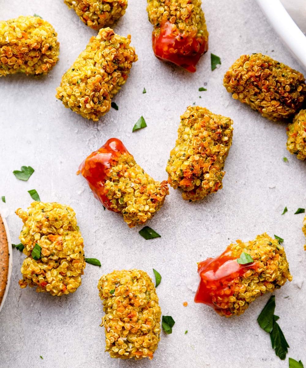 Veggie tots dunked in ketchup with salt flakes and parsley.