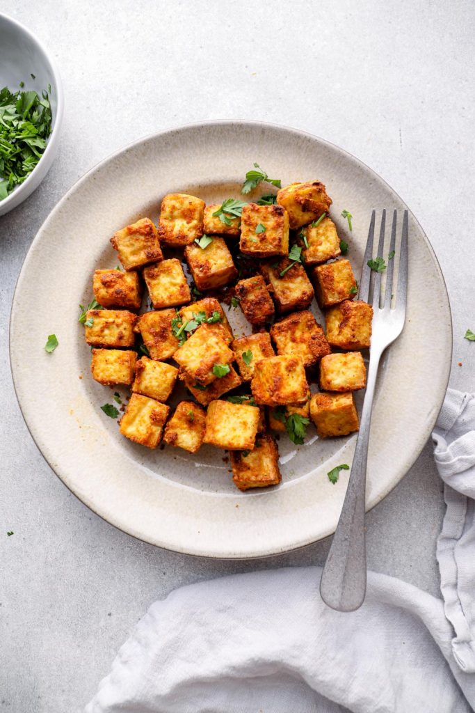 Air fried tofu on a plate with cilantro.