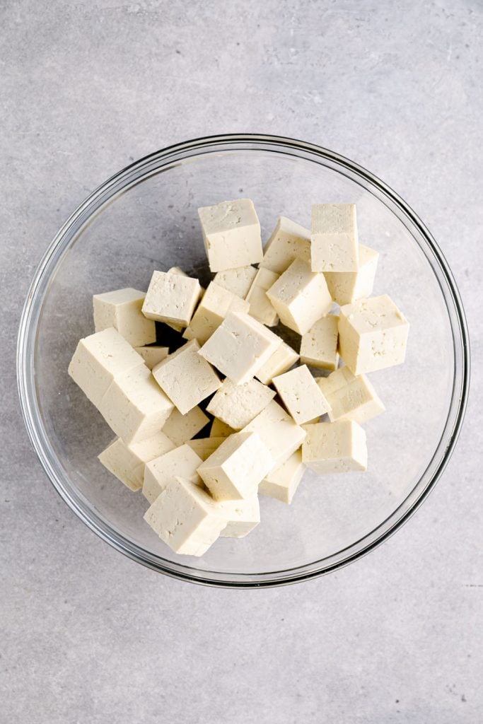 A glass bowl with cubed tofu.