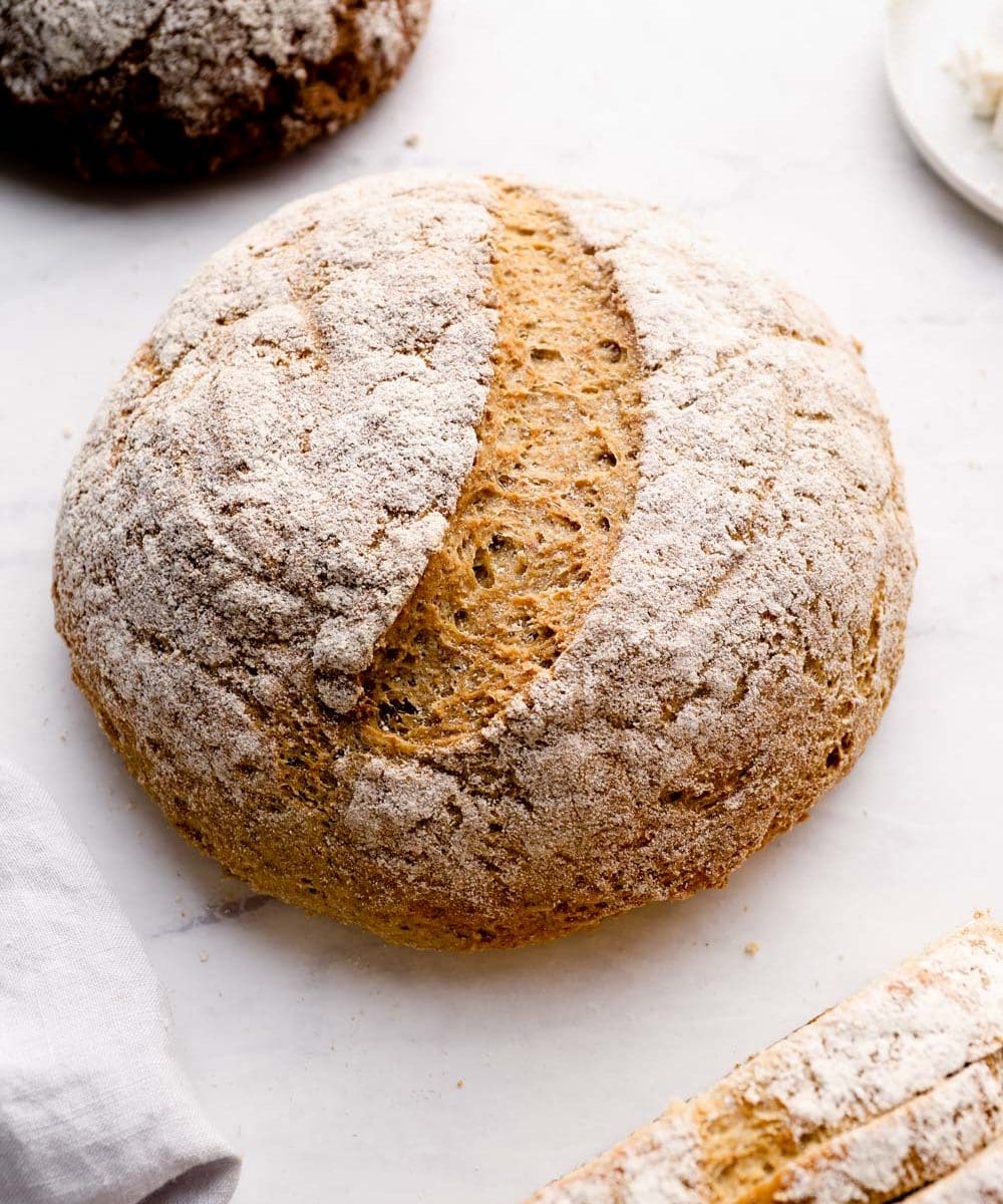 A loaf of artisan gluten free bread dusted with flour.