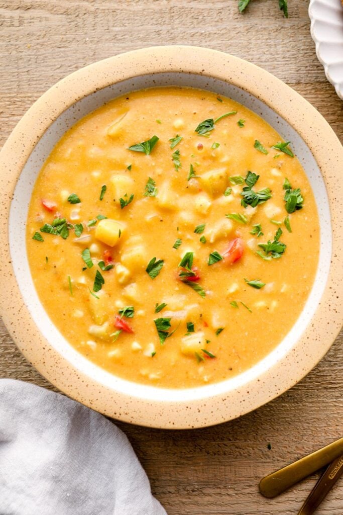 Corn soup with potatoes and bell peppers in a bowl.
