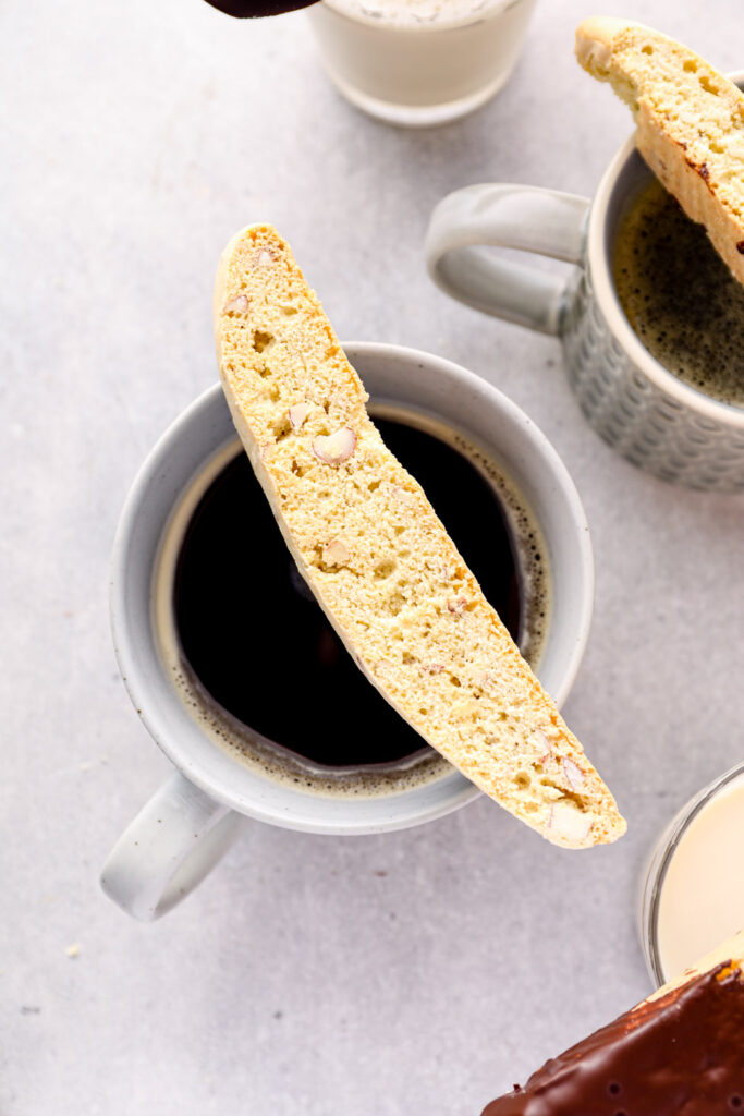 A gluten free almond biscotti on a coffee cup.