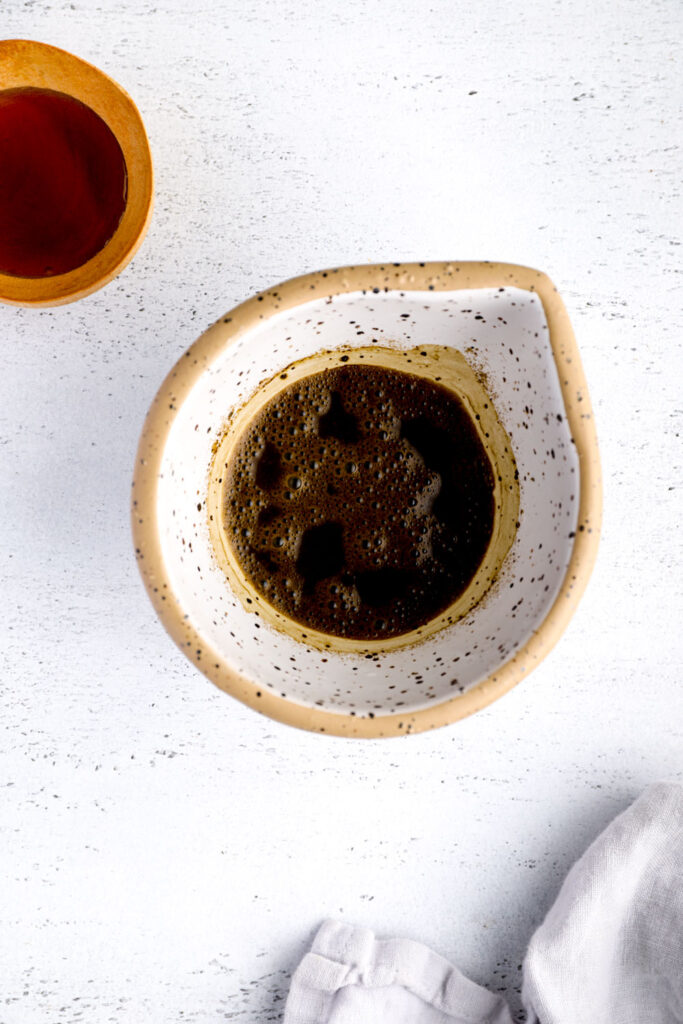 Hojicha tea mixed with boiling water in a white bowl.