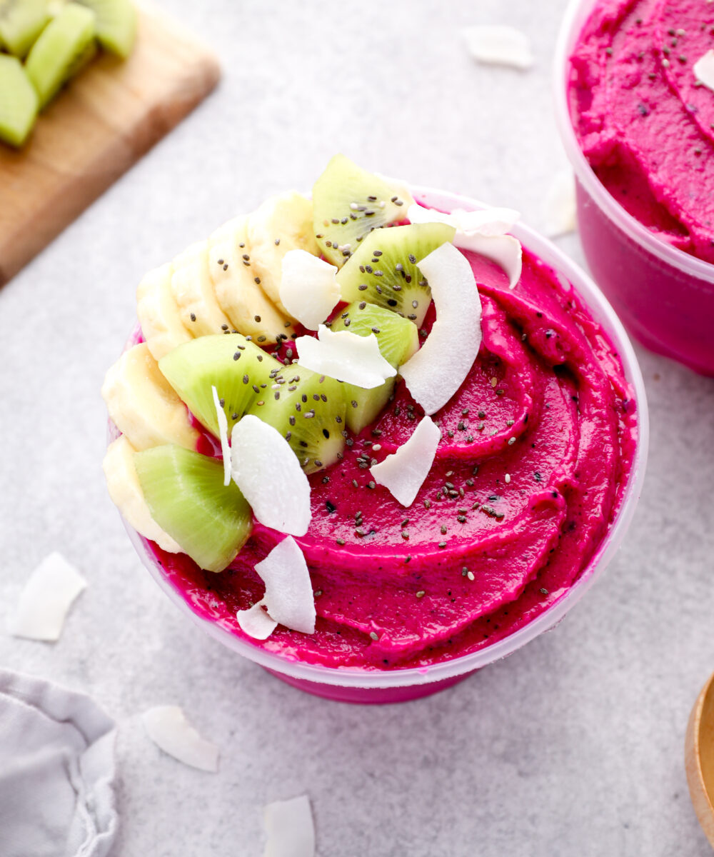 A dragon fruit smoothie bowl topped with banana and chia seeds.